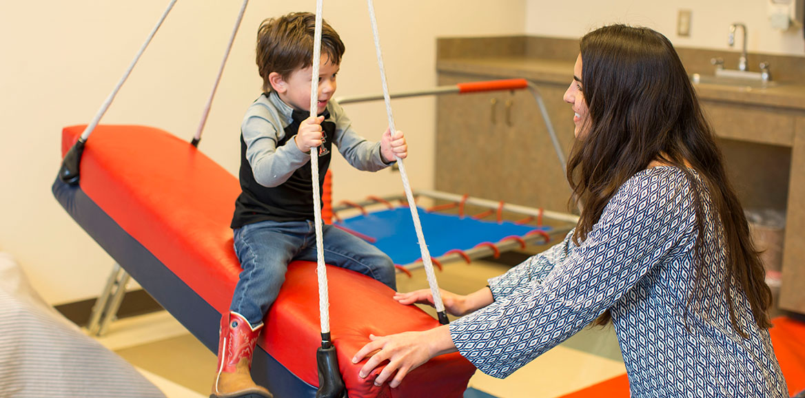 A speech-language pathology student works with a child in one of the TTUHSC speech clinic rooms.