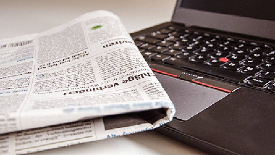 newspaper on a laptop's keyboard